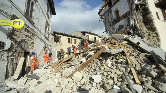 Los rescatistas llevan en camilla a una de las víctimas a través de un edificio en ruinas en Arquata del Tronto. 
